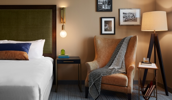 Bed next to the arm chair and lamp