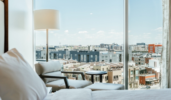 Closeup shot of bed next to the armchair by the window