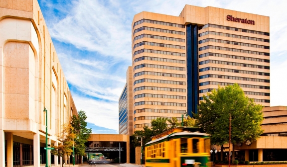 Exterior of Sheraton Memphis Downtown with streetcar in foreground.
